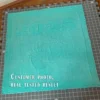 Minimalist knitted baby blanket with “2025” and baby feet motif in textured garter stitch on a smooth stockinette background, finished with a wide garter stitch border. Neutral turquoise newborn blanket design for stroller, nursery, baby shower gift, or pregnancy announcement photo prop.