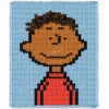 Pixel-style chunky knit blanket featuring Franklin from the Peanuts comic series on a light blue background. The design shows Franklin with curly dark brown hair, a smiling face, and a red shirt with black details, knitted in chunky jumbo yarn with a soft textured finish.