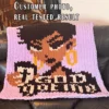 God Got Me chunky knit blanket pattern featuring a portrait of a Black woman with a short haircut holding a coffee cup, set against a pink background with the text God Got Me in black and white lettering, knitted in jumbo yarn using finger knitting colorwork technique.