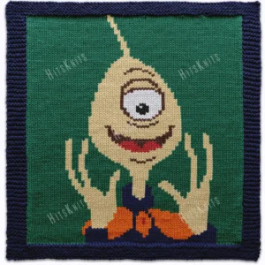 Hand-knitted Pleakley character square panel with a navy garter stitch border on a green background. The design features Pleakley from Disney’s Lilo & Stitch with one large eye, a smiling expression, raised hands, and a long antenna. Colorwork knitting design created using navy, green, cream, brown, gold, white, red, and black shades.