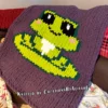 Cute frog chunky knit blanket with pixel art frog design on a lavender background. Finger knitting and jumbo yarn pattern suitable for nursery décor, kids’ blankets, cozy room accents, and handmade gifts.