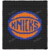 Black chunky knit blanket featuring the iconic New York Knicks basketball logo in bright orange and blue, created in a bold pixel-style design with jumbo chenille yarn and textured finger-knitted stitches.