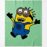A playful corner-to-corner crochet blanket featuring a cheerful Minion character with raised arms, dressed in bright blue overalls with black gloves and shoes. The design is worked on a soft mint green background, making the bold yellow, blue, black, white, and gray details stand out beautifully.