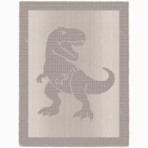 Knitted blanket featuring a textured Tyrannosaurus rex silhouette in the center, worked in garter stitch against a stockinette background. The blanket has a wide textured border framing the dinosaur design. The T-Rex is shown in a standing pose with detailed claws, tail, and open mouth, suitable for dinosaur lovers, teens, and adults.