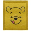 Pooh Bear Pram Blanket Knitting Pattern, a knitted baby blanket showing a golden honey bear face in intarsia colorwork with a black outline and a small red detail, worked in stockinette with a garter stitch border.