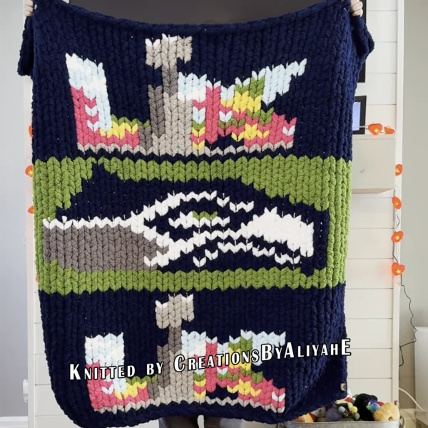 Seahawks Finger Knit Blanket Pattern - the Seattle Seahawks seahawk-head logo on a green field with Super Bowl LX 2026 emblems on a navy background, worked in stockinette colorwork intarsia with 8 colors: Navy, Green, White, Gray, Graphite, Sky, Lilac, Gold.