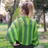 Easy striped lace bolero knitting pattern showing a loose summer shrug worked in thin cotton yarn with lace eyelet rows at each colour change, in coral and red stripes, one size fits most.