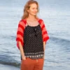Easy striped lace bolero knitting pattern showing a loose summer shrug worked in thin cotton yarn with lace eyelet rows at each colour change, in coral and red stripes, one size fits most.