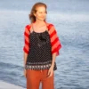Easy striped lace bolero knitting pattern showing a loose summer shrug worked in thin cotton yarn with lace eyelet rows at each colour change, in coral and red stripes, one size fits most.
