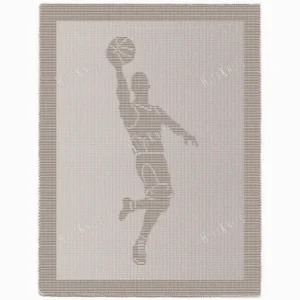 Basketball Player Blanket Knitting Pattern showing a textured silhouette of a basketball player mid jump shot with the ball above the hoop, on a solid single-colour blanket with a garter stitch border, worked in one colour, 220 stitches x 396 rows.