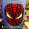 Spider Man Superhero Finger Knitting Pattern showing a red Marvel Spiderman (Spider-Man) web mask with black web lines and large white eyes outlined in black on a blue background, worked in stockinette colorwork intarsia with 4 colors: Blue, Black, Red, and White.
