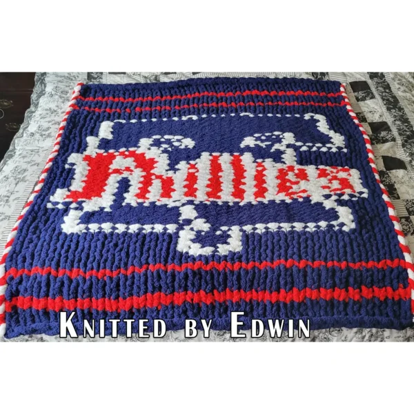 Phillies Finger Knitting Blanket Pattern showing the red Phillies script logo with a white Liberty Bell above and a star below on a blue background, worked in stockinette colorwork intarsia with 3 colors: Blue, White, and Red.