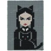 Wednesday Addams Knit Chunky Blanket Pattern showing a portrait of Wednesday Addams in a cat costume with pointed ears, pale face, red lips, dark braids, a white collar and a small black cat, on a teal background, worked in stockinette colorwork with 5 colors: Teal, Black, Powder, White, and Red.