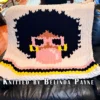 Bubblegum Chunky Blanket Finger Knitting Pattern showing a girl with a black afro, camel skin, pink sunglasses, and gold hoop earrings blowing a pink bubblegum bubble on an ivory background with pink, black, and yellow stripes, worked in stockinette colorwork intarsia with 5 colors: Ivory, Black, Pink, Yellow, and Camel.