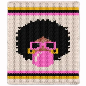 Bubblegum Chunky Blanket Finger Knitting Pattern showing a girl with a black afro, camel skin, pink sunglasses, and gold hoop earrings blowing a pink bubblegum bubble on an ivory background with pink, black, and yellow stripes, worked in stockinette colorwork intarsia with 5 colors: Ivory, Black, Pink, Yellow, and Camel.