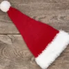 Santa Hat Knitting Pattern showing a long red knitted Santa hat with a soft fluffy white brim and a white pompom, an easy knit and purl Christmas hat for adults.
