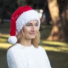 Santa Hat Knitting Pattern showing a long red knitted Santa hat with a soft fluffy white brim and a white pompom, an easy knit and purl Christmas hat for adults.