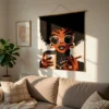 Coffee Lady Crochet Blanket Pattern showing a stylish Black woman with an afro, round sunglasses, gold hoop earrings and a necklace, holding a coffee cup, worked in single crochet intarsia colorwork with 6 colors: Black, White, Camel, Beige, Brown, and Gray.