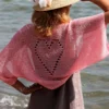 Lace Heart Bolero Knitting Pattern showing a lightweight pink lace shrug with an eyelet heart motif on the back, worked in sport weight cotton, sizes XS to 4XL.