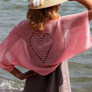 Lace Heart Bolero Knitting Pattern showing a lightweight pink lace shrug with an eyelet heart motif on the back, worked in sport weight cotton, sizes XS to 4XL.