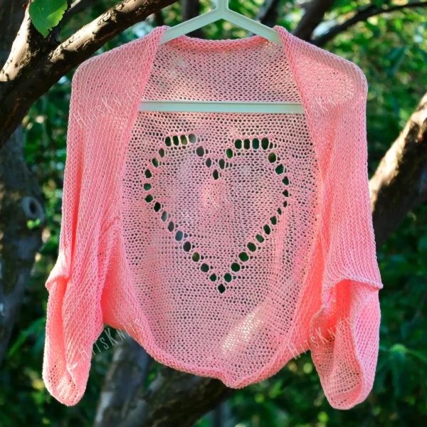 Lace Heart Bolero Knitting Pattern showing a lightweight pink lace shrug with an eyelet heart motif on the back, worked in sport weight cotton, sizes XS to 4XL.