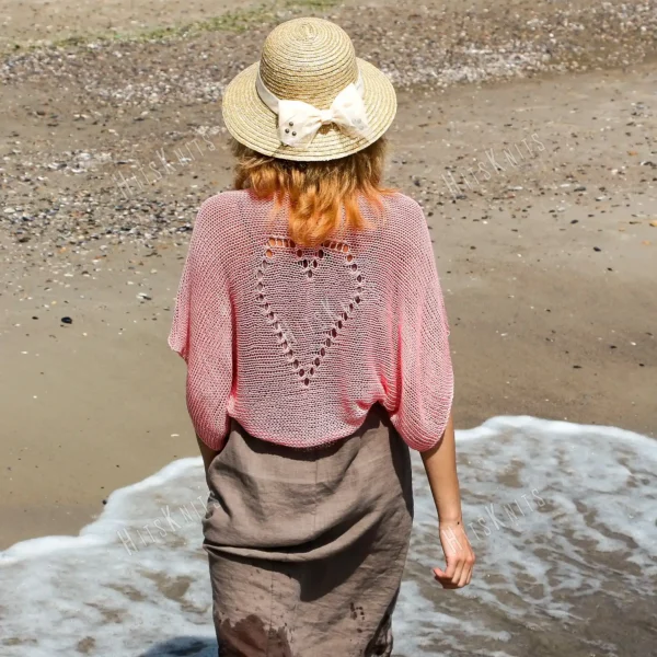 Lace Heart Bolero Knitting Pattern showing a lightweight pink lace shrug with an eyelet heart motif on the back, worked in sport weight cotton, sizes XS to 4XL.