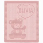 Olivia Stroller Blanket Knitting Pattern showing a textured teddy bear holding a heart-shaped balloon with the name Olivia inside, on a solid dusty rose blanket with a garter stitch border, worked in one color, 130 stitches x 230 rows.
