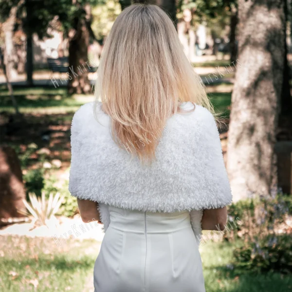 Free Faux Fur Wedding Poncho Knitting Pattern showing a soft white fluffy triangular poncho draped over the shoulders with a long front point, worked in garter stitch, one size fitting S, M, and L.