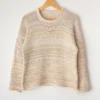 Cozy Women's Basic Sweater Knitting Pattern showing a relaxed drop-shoulder pullover in marled cream, oat, and sand, worked in stockinette stitch with rolled hem, cuffs, and neckline, sizes S to 2XL.