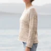 Cozy Women's Basic Sweater Knitting Pattern showing a relaxed drop-shoulder pullover in marled cream, oat, and sand, worked in stockinette stitch with rolled hem, cuffs, and neckline, sizes S to 2XL.