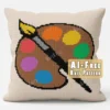 Artist Palette Knit Pillow Panel Pattern - a brown artist's paint palette with six colorful paint blobs and a paintbrush on a cream background, worked in stockinette colorwork intarsia with 10 colors.
