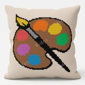 Artist Palette Knit Pillow Panel Pattern - a brown artist's paint palette with six colorful paint blobs and a paintbrush on a cream background, worked in stockinette colorwork intarsia with 10 colors.