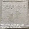 Minimalist knitted baby blanket with “2025” and baby feet motif in textured garter stitch on a smooth stockinette background, finished with a wide garter stitch border. Neutral blue newborn blanket design for stroller, nursery, baby shower gift, or pregnancy announcement photo prop.