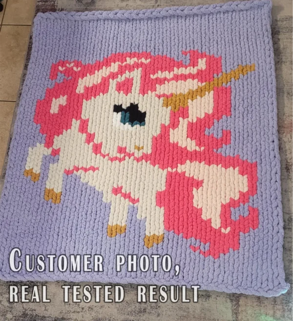 Pink Unicorn Throw Finger Knitting Pattern - cute fairytale unicorn with an ivory face, magenta and blush pink mane, and a golden horn on a purple background, worked in stockinette colorwork intarsia with 8 colors: purple, magenta, ivory, blush, gold, black, white, cyan.