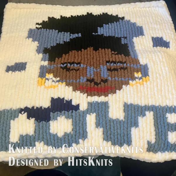 Love Yourself Finger Knit Blanket Pattern - motivational self-love portrait of an African American Black woman with an afro bun, a royal blue headband with a bow, blue glasses, gold hoop earrings and burgundy lips, above the word LOVE with floating hearts on a white background, knitted in stockinette colorwork intarsia with 8 colors: White, Royal Blue, Cornflower, Brown, Camel, Black, Gold, Burgundy.