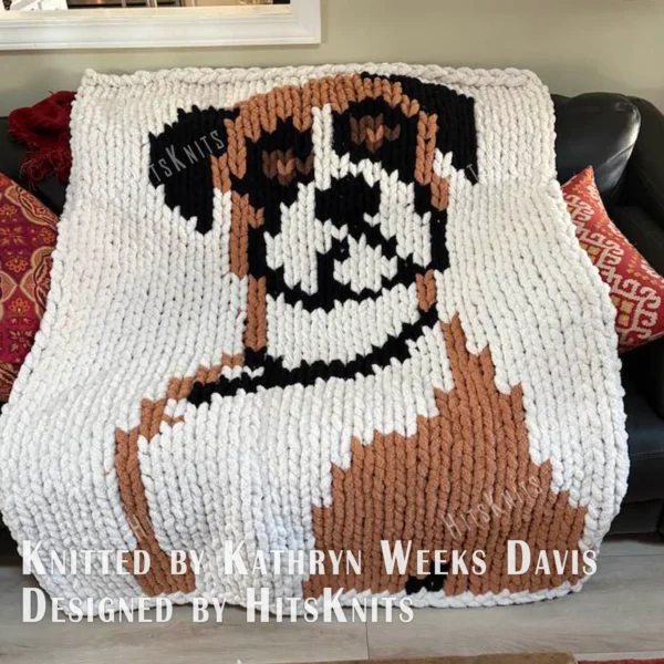 Boxer Dog Chunky Blanket Knitting Pattern - a sitting boxer dog with long floppy ears, big dark eyes, a brown nose, and a beige and brown coat on an ivory background, cute cozy mood, knitted in stockinette colorwork intarsia with 4 colors: Ivory, Beige, Brown, and Black.