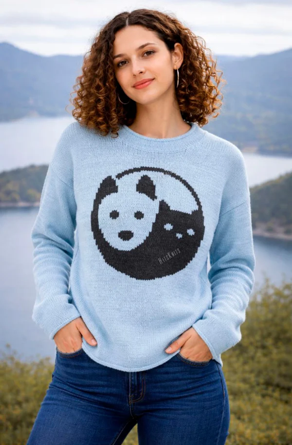 Cat and Dog Yin Yang Sweater Knitting Pattern showing a soft blue women's pullover with a black and blue yin yang motif of a cat and a dog on the front, knitted in worsted weight yarn, sizes S to 2XL.