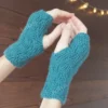 Checker Fingerless Gloves Knitting Pattern showing a pair of teal fingerless gloves with a checkerboard texture of garter and rib blocks and a thumb opening, worked in DK wool blend yarn, sizes S/M to L/XL.