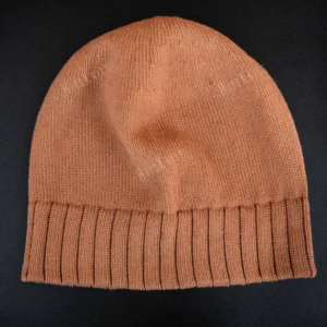 Machine Knitting Slouchy Hat Pattern showing a warm brown cotton beanie with a deep mock rib cuff, worn slouchy, knitted on a standard gauge machine, adult size 56-58 cm.